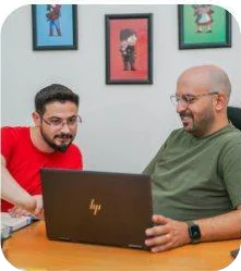 Two engineers reviewing work on a laptop